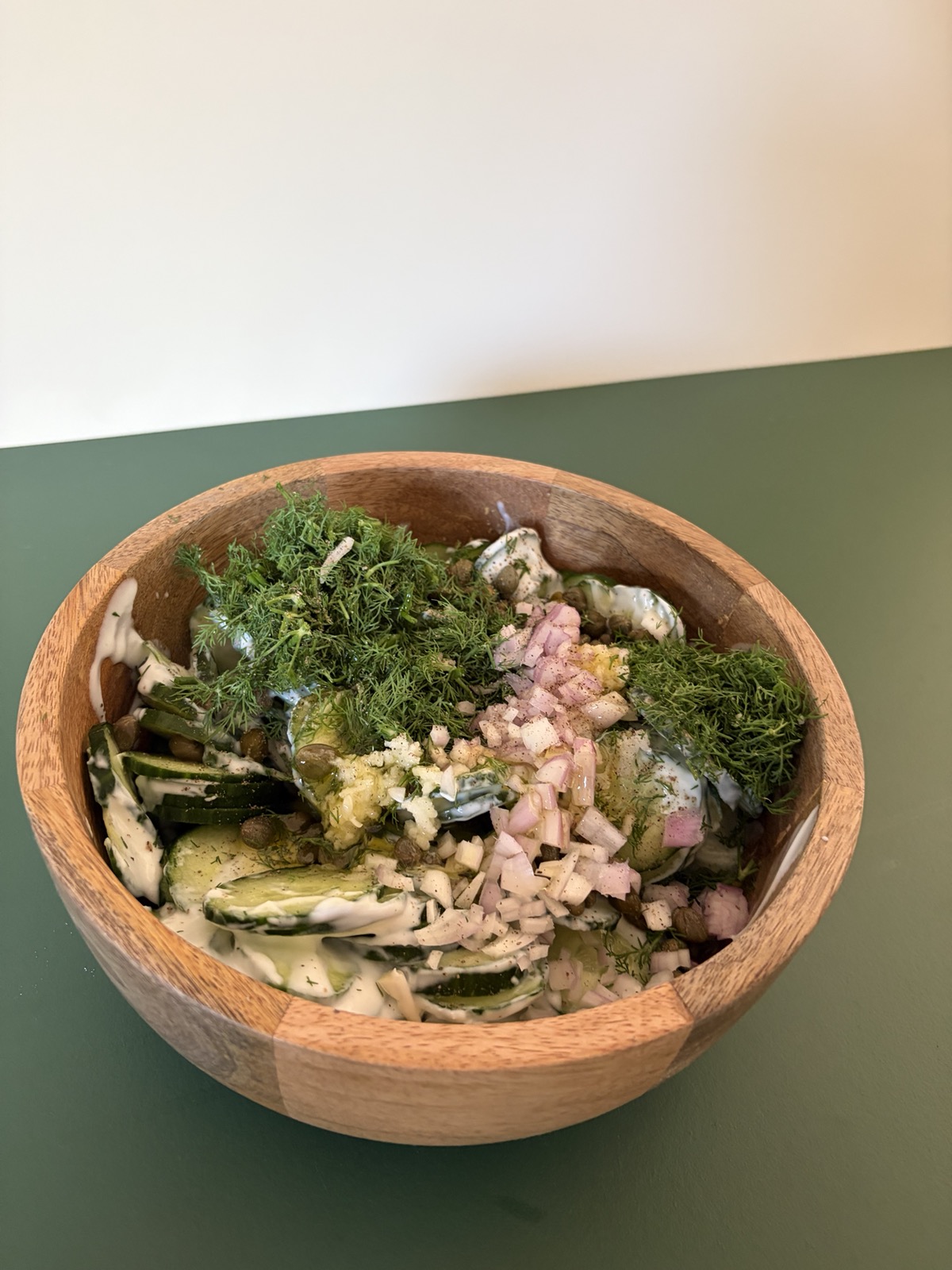 De komkommersalade in een houten kom