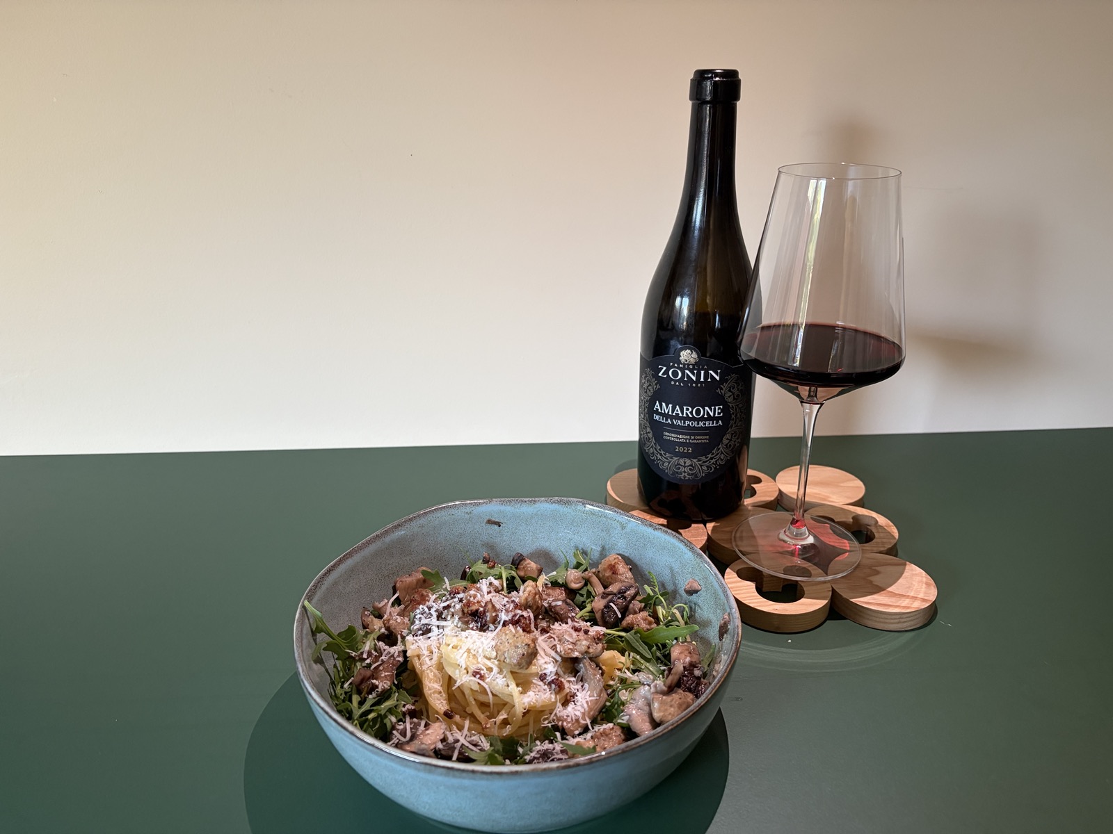 De pasta met een fles Amarone della Valpolicella (rode wijn) uit 2022 op een houten onderzetter